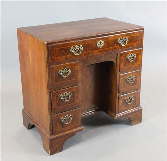 An early 18th century crossbanded kneehole desk, W.2ft 7in. D.1ft 7in. H.2ft 7in.